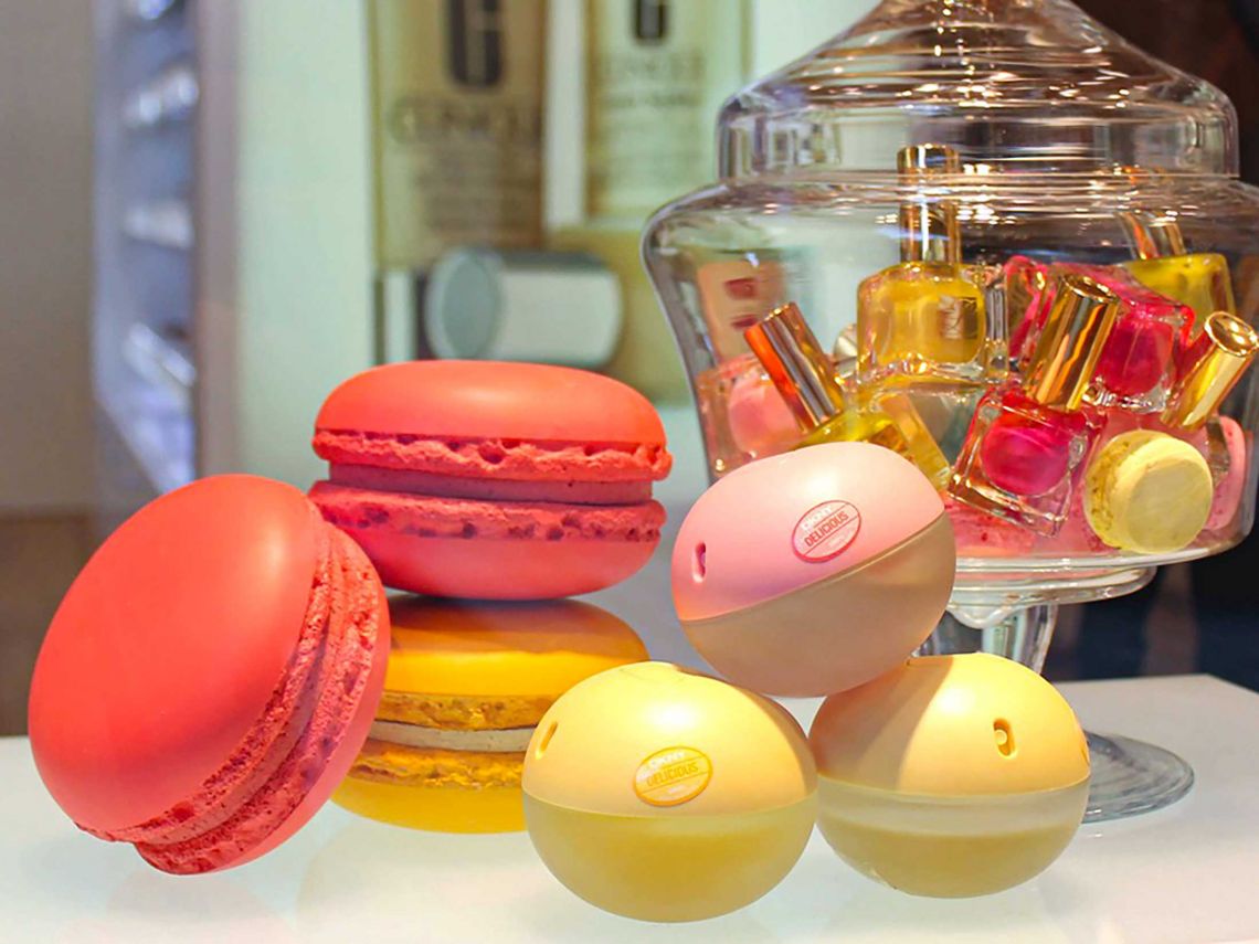 Macaron props in a promotional display with perfume and nail varnish.