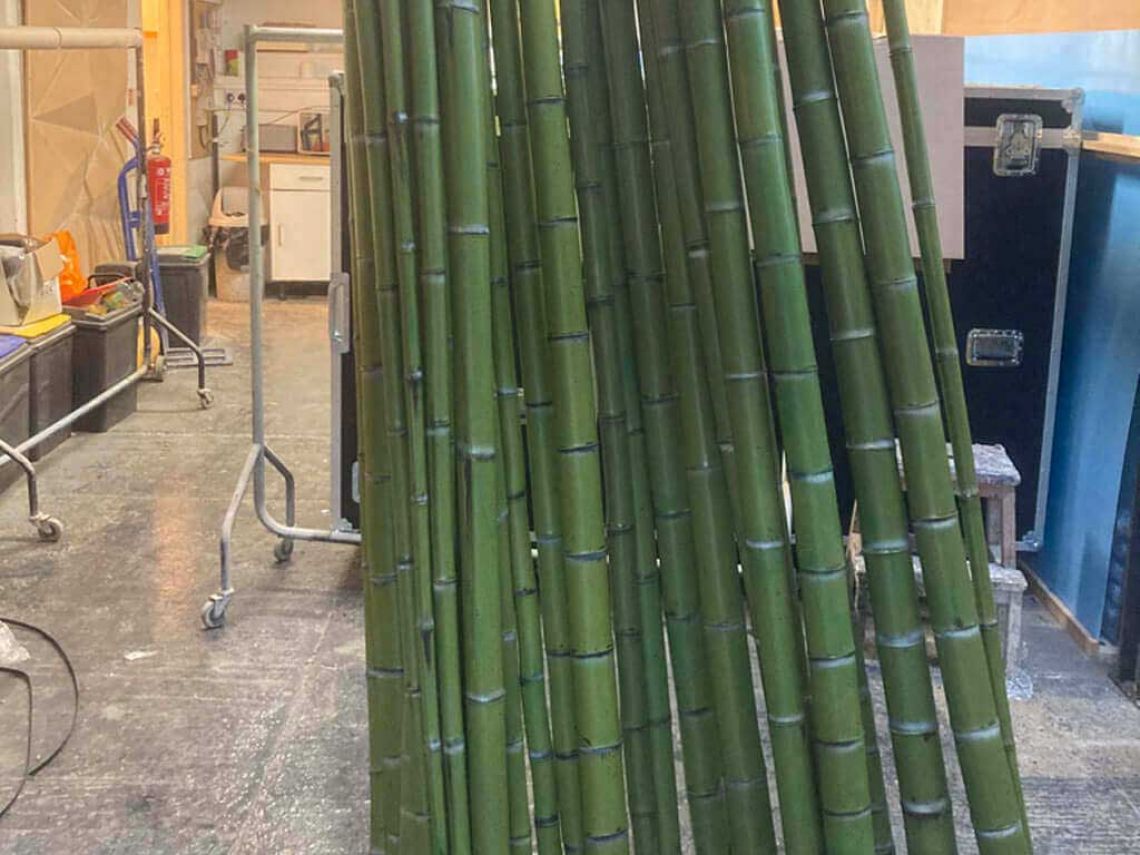 Lots of bamboo props stood up after being varnished.