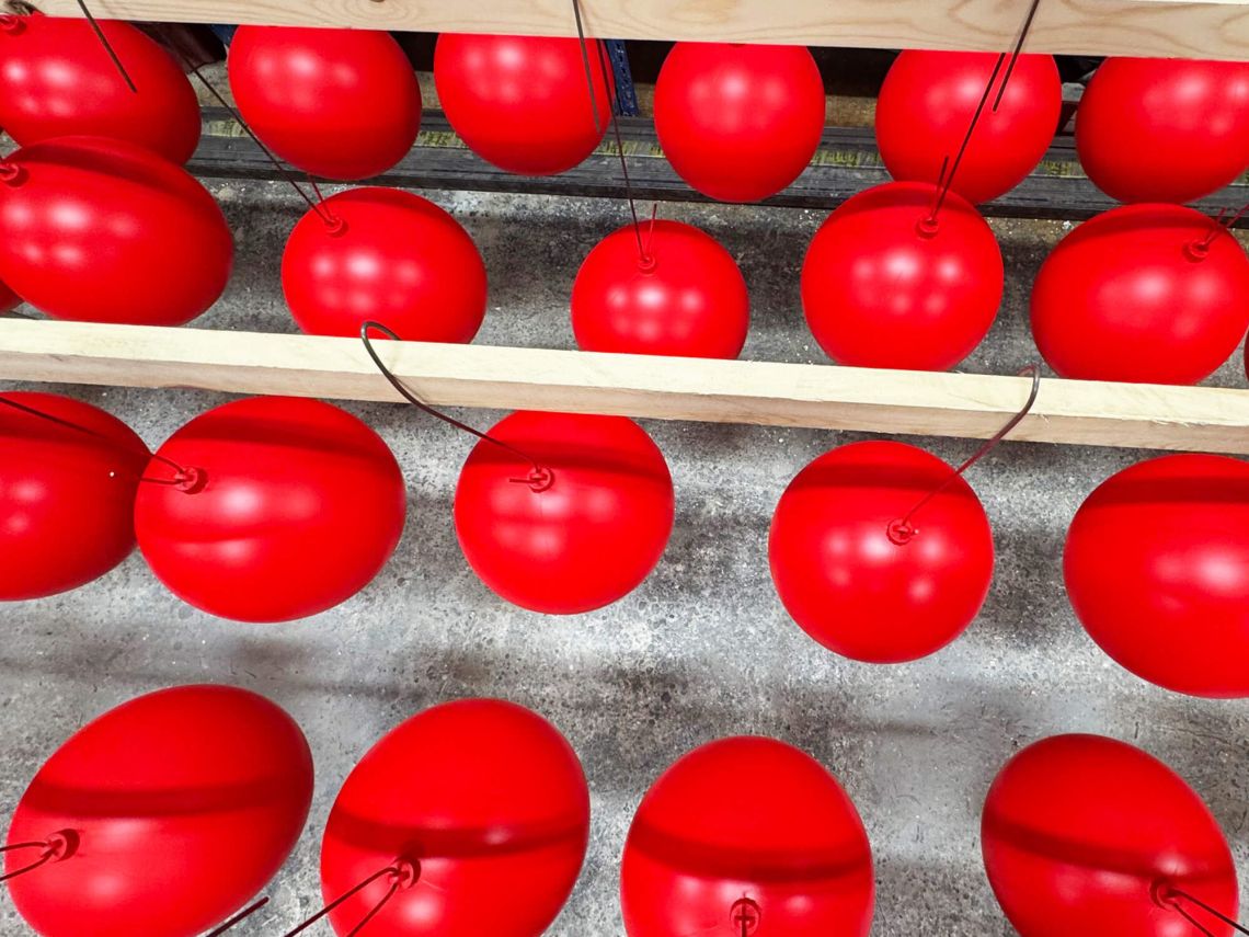 Painted baubles hanging to dry from above.